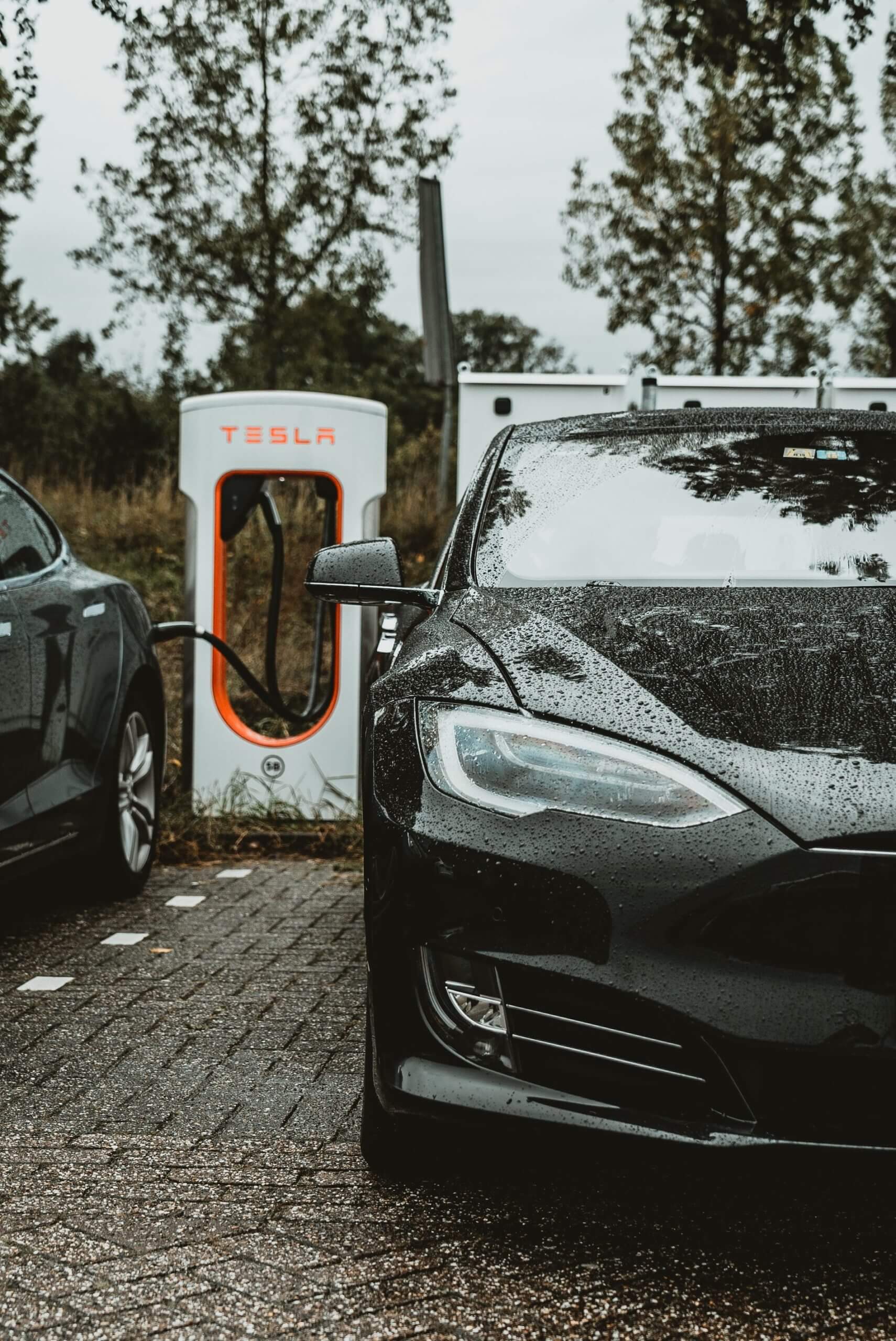 Two black Teslas at a charging station