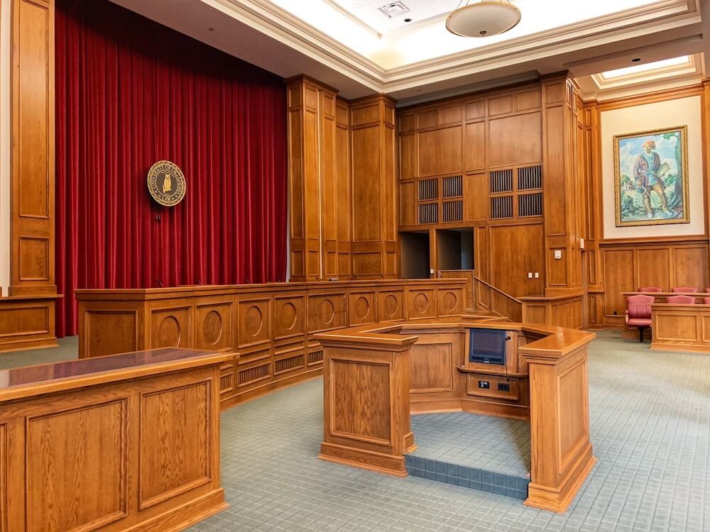 Old-style courtroom with lots of wood and maroon velvet drapes