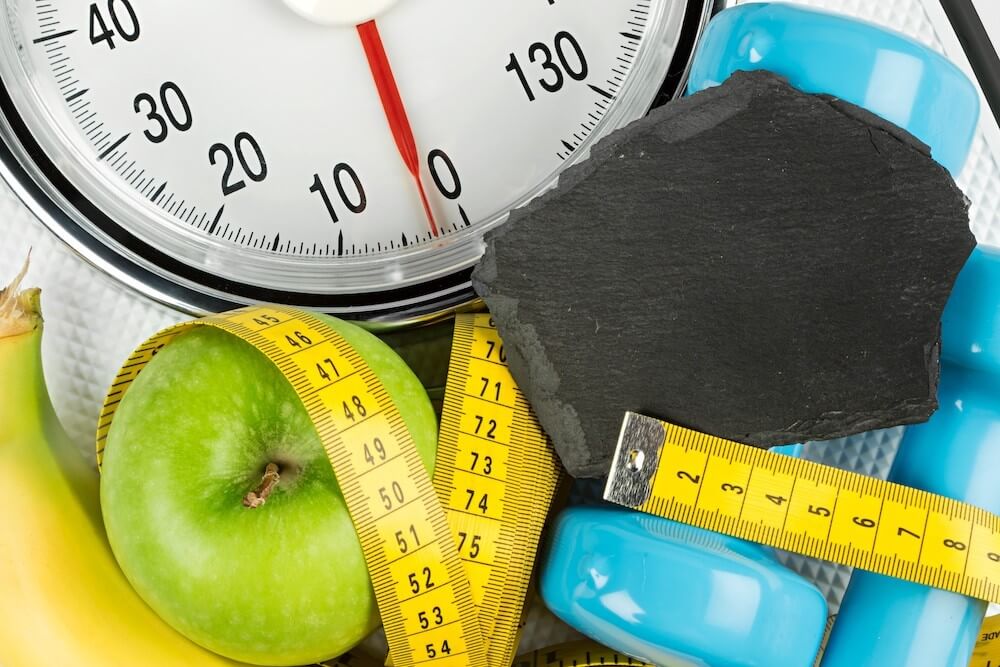 Weights, a tape measure, fruit, and a scale — all things commonly associated with New Year’s resolutions