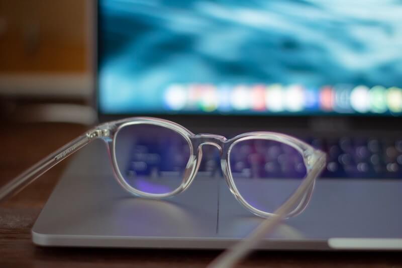 Eye glasses with clear plastic frames sitting on laptop