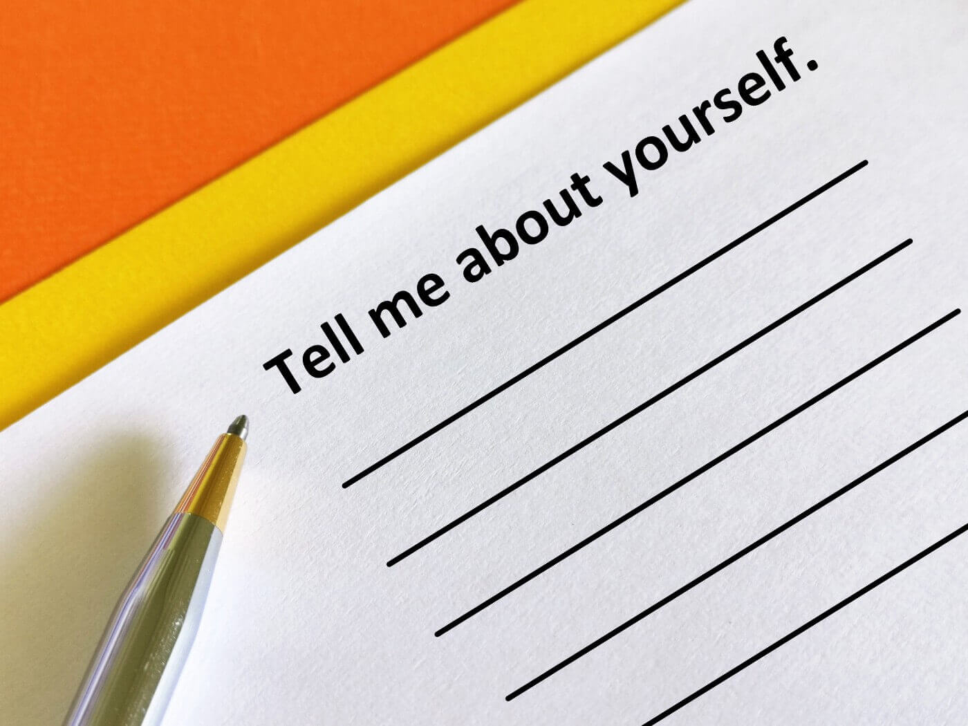 Piece of paper that says “tell me about yourself” and pen